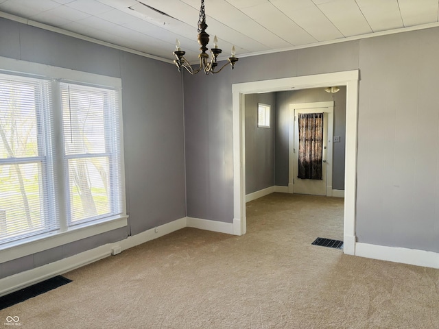 empty room featuring light carpet, a notable chandelier, and plenty of natural light