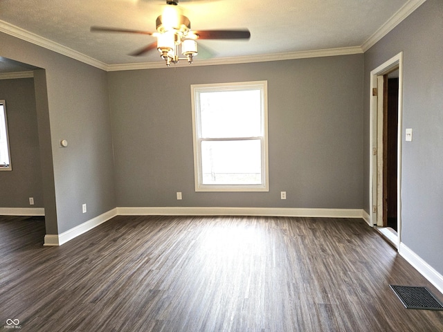 empty room featuring visible vents, baseboards, a ceiling fan, crown molding, and dark wood-type flooring