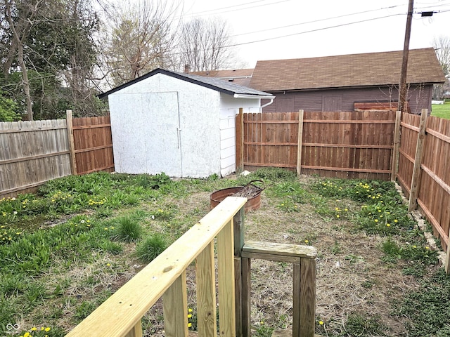 view of yard with a storage shed, a fenced backyard, and an outdoor structure