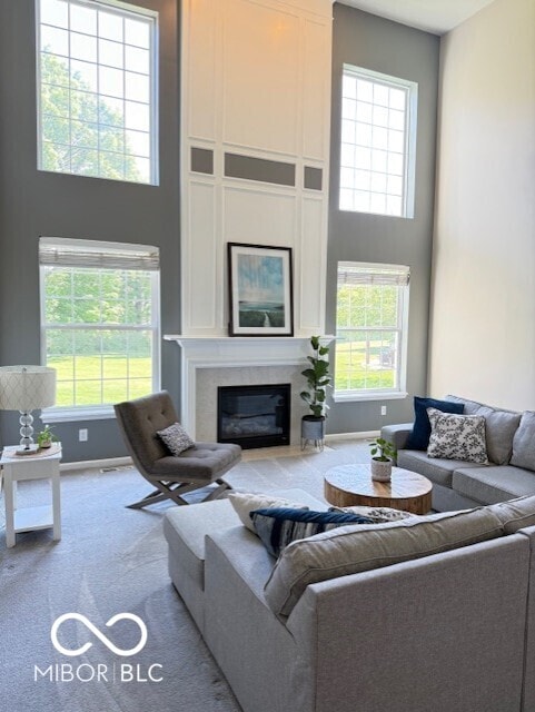 11648 Stickney Ct, Fishers, IN 46037 - living room with carpet, a towering ceiling, healthy amount of natural light, a large fireplace, and baseboards