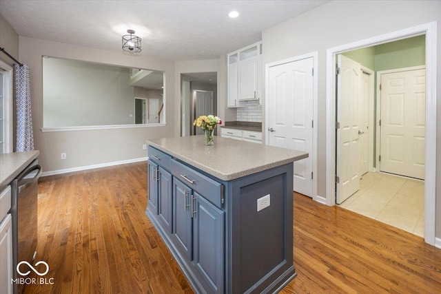 11648 Stickney Ct, Fishers, IN 46037 - kitchen with white cabinets, blue cabinets, a center island, stainless steel dishwasher, and wood finished floors