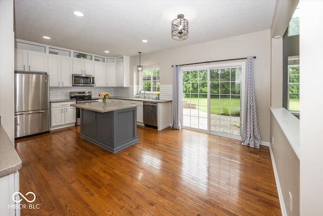 11648 Stickney Ct, Fishers, IN 46037 - kitchen featuring appliances with stainless steel finishes, a sink, white cabinets, tasteful backsplash, and a kitchen island