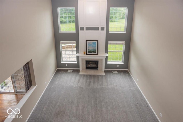 11648 Stickney Ct, Fishers, IN 46037 - unfurnished living room with carpet, baseboards, a towering ceiling, and a fireplace with flush hearth