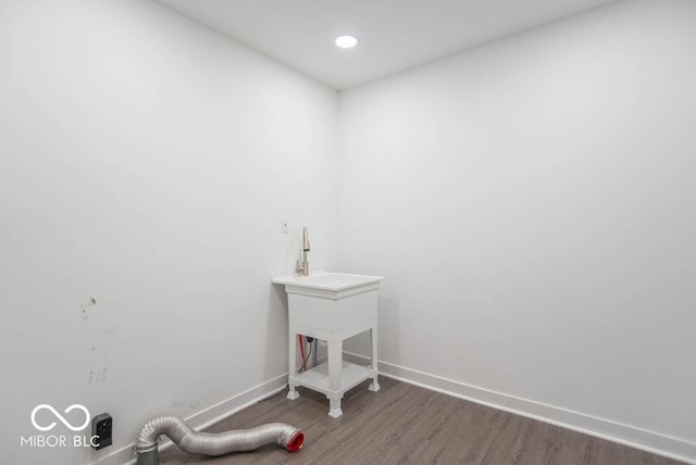 laundry room featuring baseboards, recessed lighting, and wood finished floors