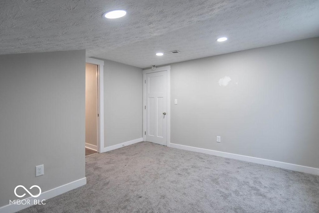 finished basement with visible vents, baseboards, recessed lighting, a textured ceiling, and carpet flooring