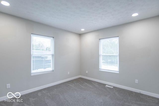 carpeted empty room with baseboards, recessed lighting, and a wealth of natural light