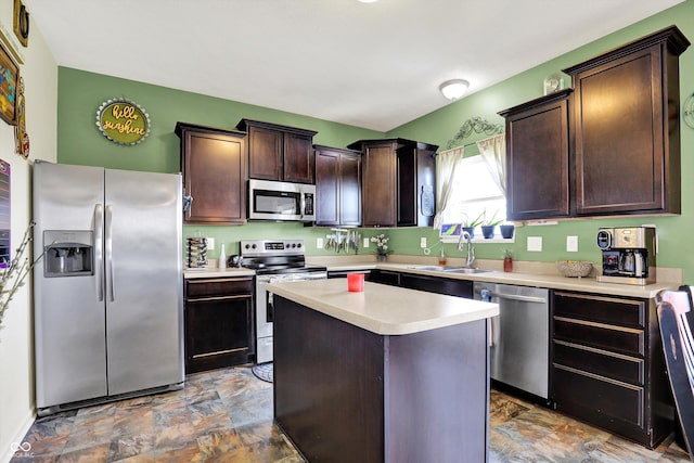 950 Redwood Dr, Franklin, IN 46131 - kitchen featuring appliances with stainless steel finishes, dark brown cabinetry, light countertops, a center island, and stone finish flooring