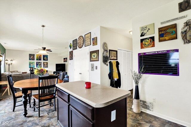 950 Redwood Dr, Franklin, IN 46131 - kitchen featuring a ceiling fan, open floor plan, a kitchen island, light countertops, and dark brown cabinetry