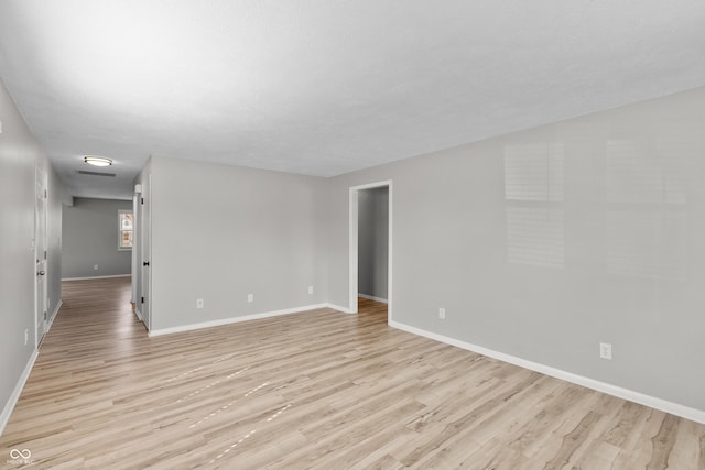 unfurnished room with light wood finished floors and baseboards