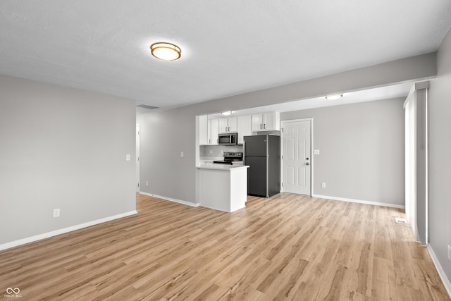 unfurnished living room with visible vents, light wood-style flooring, and baseboards