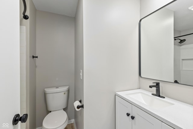 full bathroom with vanity, a shower, and toilet