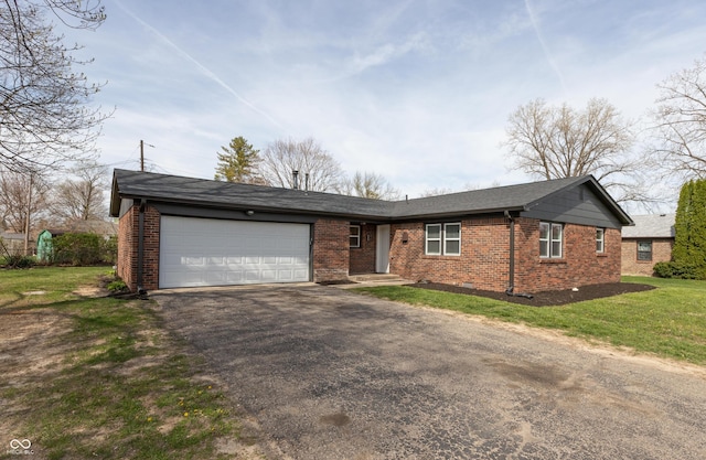 ranch-style home with an attached garage, driveway, brick siding, and a front yard