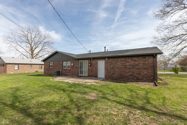 rear view of house with brick siding, central air condition unit, a lawn, and a patio