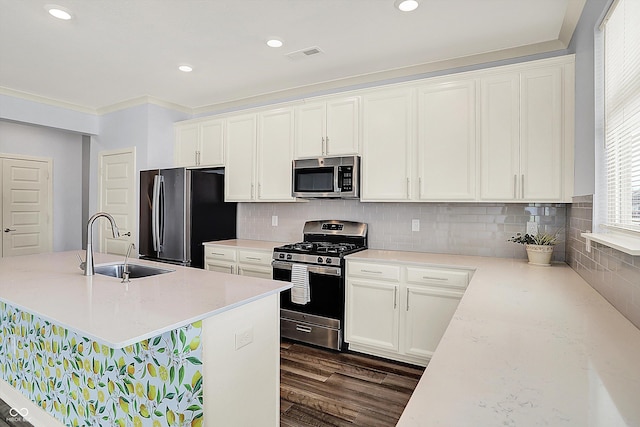 kitchen with white cabinets, appliances with stainless steel finishes, a sink, and dark wood-style floors