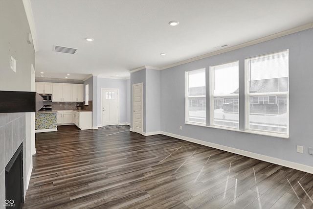 unfurnished living room featuring dark wood finished floors, crown molding, visible vents, and recessed lighting