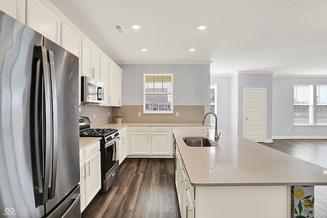 kitchen featuring ornamental molding, stainless steel appliances, dark wood-type flooring, and a sink