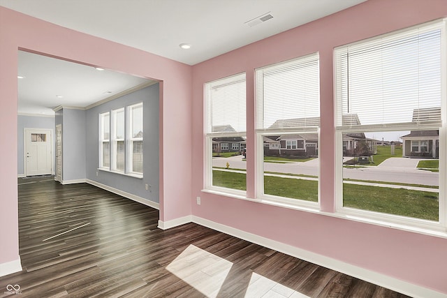 unfurnished room with baseboards, visible vents, and dark wood finished floors