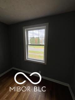 517 Dicks St, Lebanon, IN 46052 - spare room featuring dark wood-type flooring and baseboards
