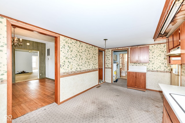 2001 S I St, Elwood, IN 46036 - kitchen featuring wallpapered walls, brown cabinetry, an inviting chandelier, light countertops, and decorative light fixtures
