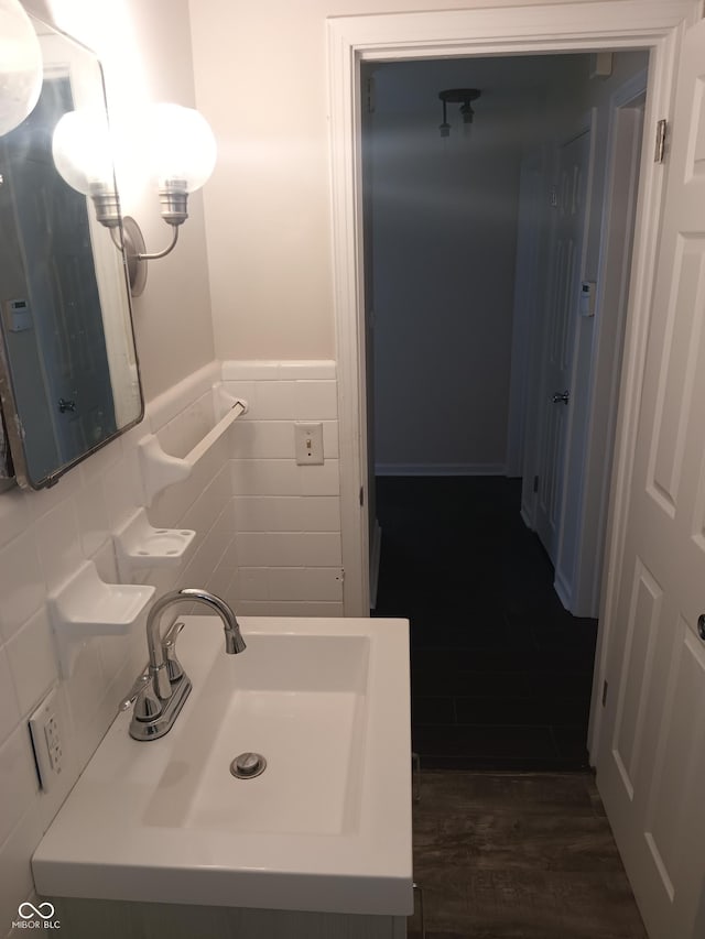 bathroom with tile walls, a wainscoted wall, vanity, and wood finished floors
