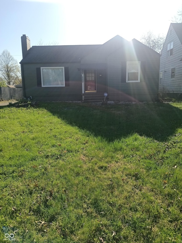 view of front of property featuring a front yard and a chimney