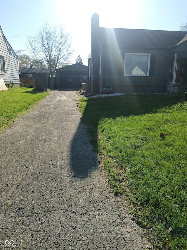 view of side of home with a garage, fence, and a lawn