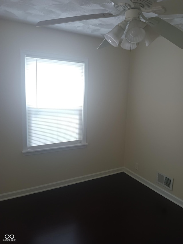 empty room featuring ceiling fan, baseboards, and visible vents