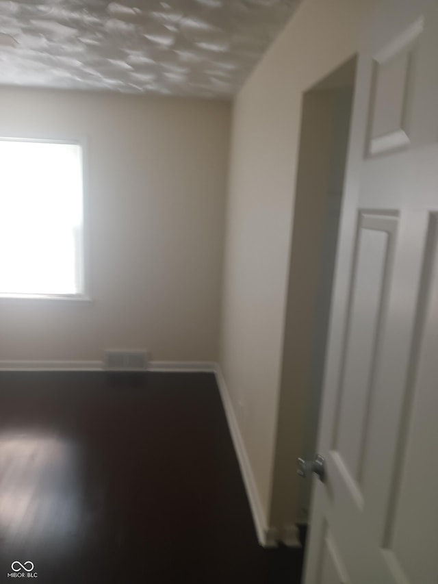 unfurnished room with baseboards