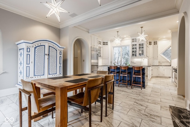 290 Breakwater Dr, Fishers, IN 46037 - dining space featuring arched walkways, light marble finish floors, crown molding, a chandelier, and baseboards