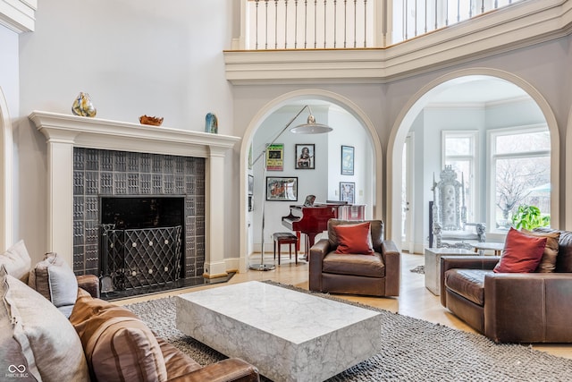 290 Breakwater Dr, Fishers, IN 46037 - living room with arched walkways, a tiled fireplace, a high ceiling, and wood finished floors
