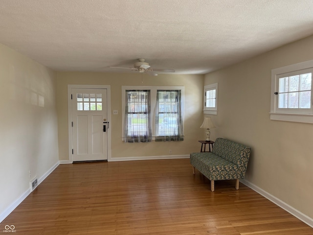 entrance foyer with plenty of natural light, light wood-style flooring, visible vents, and ceiling fan