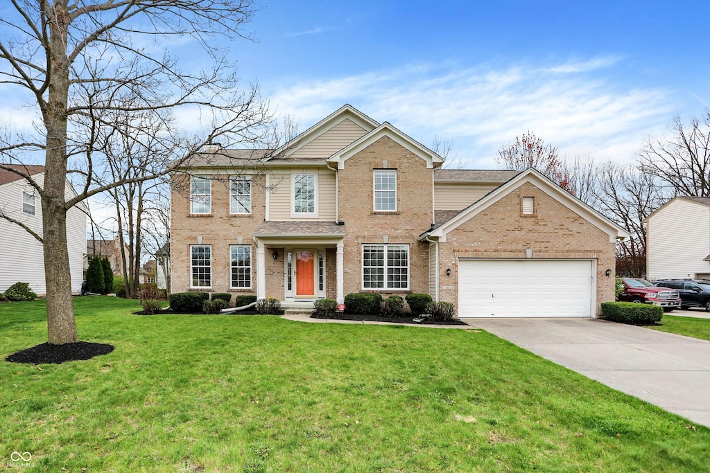 view of front facade featuring a front yard, brick siding, driveway, and an attached garage