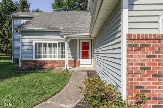 8160 Bold Forbes Ct, Indianapolis, IN 46217 - view of exterior entry featuring roof with shingles, a yard, and brick siding