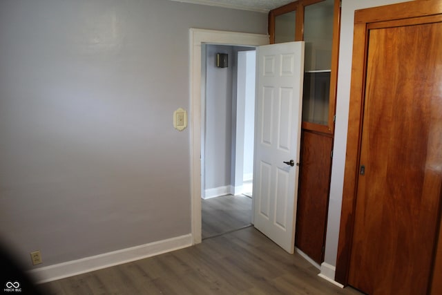interior space with baseboards and dark wood-type flooring