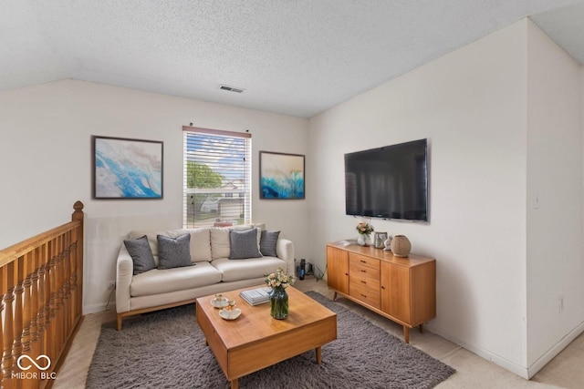 living area with light colored carpet, baseboards, visible vents, and a textured ceiling