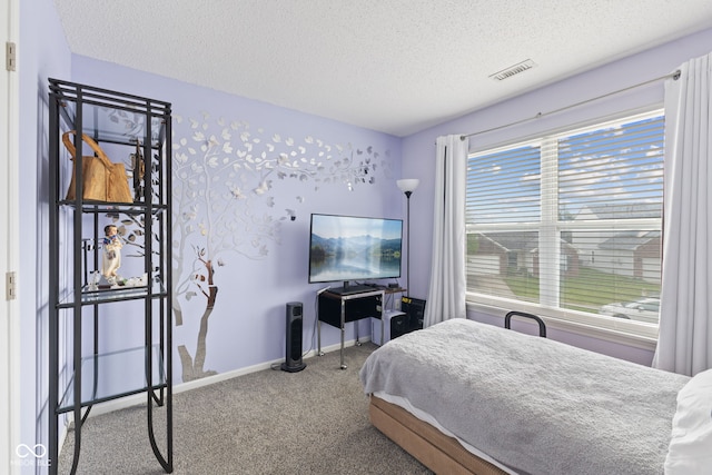 bedroom featuring visible vents, a textured ceiling, carpet floors, and baseboards
