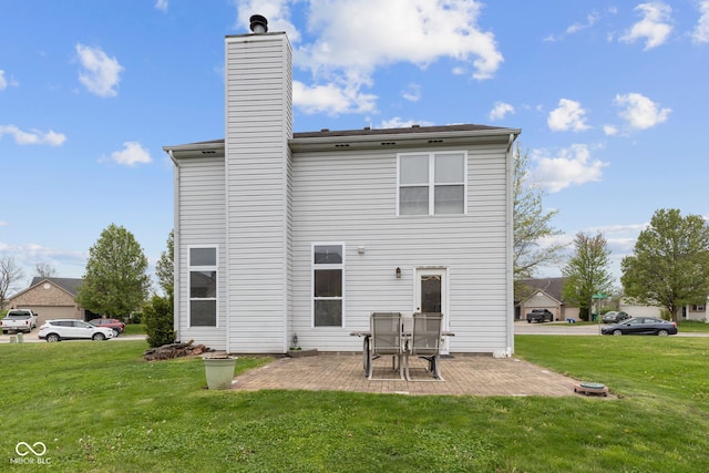 rear view of house with a lawn, a patio area, and a chimney