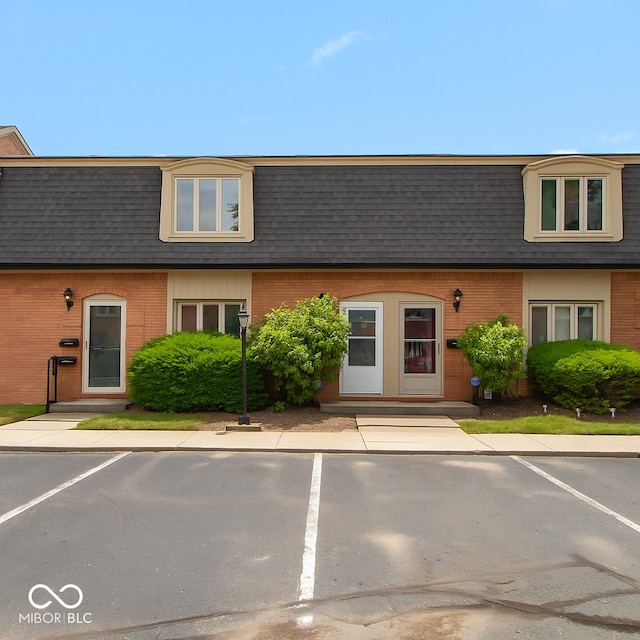 1131 Canterbury Sq S, Indianapolis, IN 46260 - view of front of property featuring mansard roof, a shingled roof, and brick siding