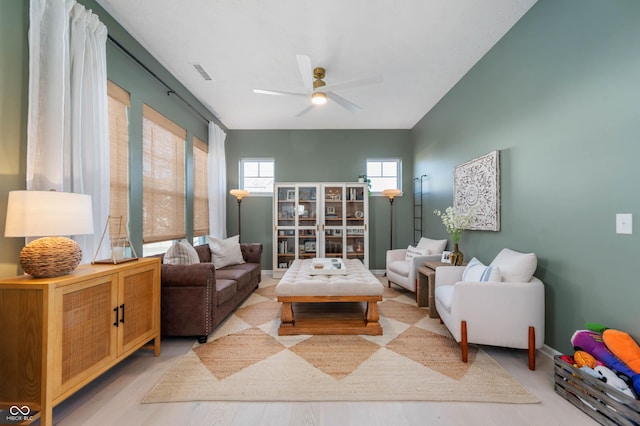 living area featuring a ceiling fan, visible vents, and light wood-style flooring