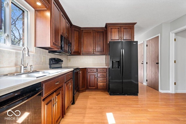 315 Heritage Ct, Fishers, IN 46038 - kitchen with a sink, black appliances, light wood-style floors, light countertops, and backsplash