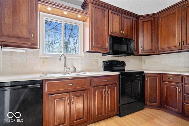 315 Heritage Ct, Fishers, IN 46038 - kitchen with light wood finished floors, light countertops, a sink, and black appliances