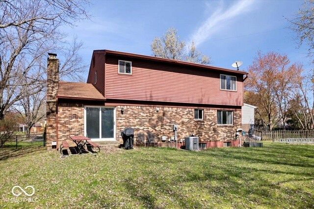 315 Heritage Ct, Fishers, IN 46038 - back of house featuring central AC, a chimney, fence, a yard, and brick siding