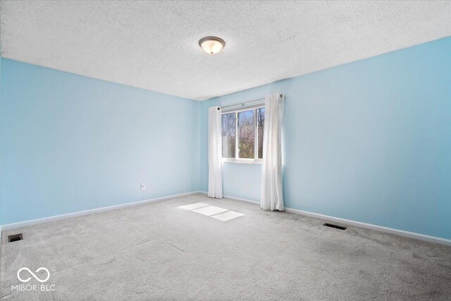 315 Heritage Ct, Fishers, IN 46038 - empty room featuring a textured ceiling, visible vents, carpet flooring, and baseboards