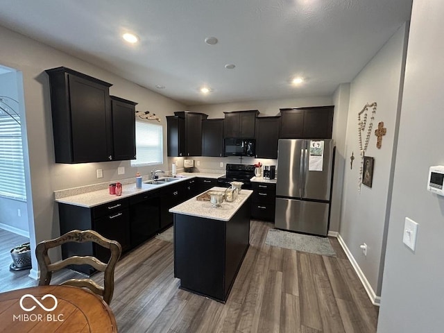1573 Vera Blvd, Danville, IN 46122 - kitchen with a center island, baseboards, light countertops, black appliances, and wood finished floors