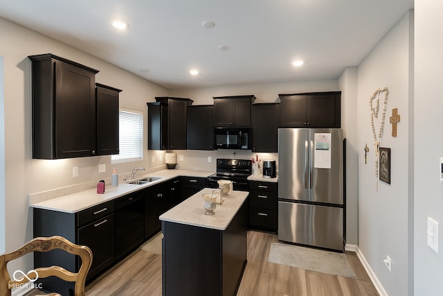 1573 Vera Blvd, Danville, IN 46122 - kitchen featuring black appliances, light wood-style flooring, a kitchen island, and dark cabinets