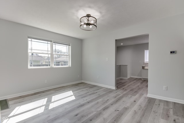 1125 N Colorado Ave, Indianapolis, IN 46201 - spare room with plenty of natural light, visible vents, light wood finished floors, and a notable chandelier