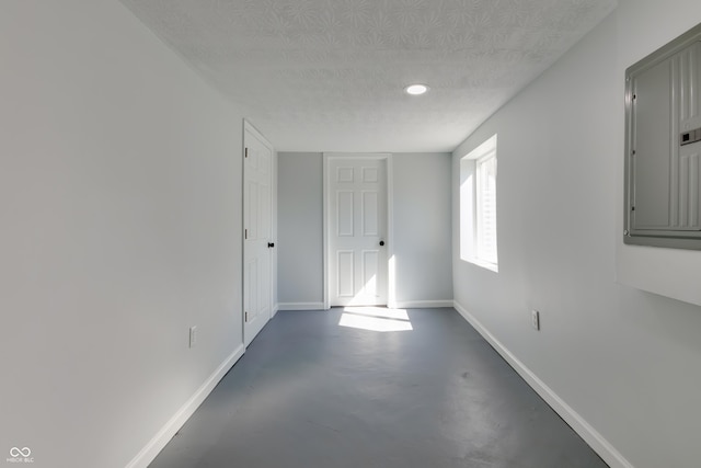 1125 N Colorado Ave, Indianapolis, IN 46201 - empty room featuring electric panel, a textured ceiling, baseboards, recessed lighting, and concrete floors