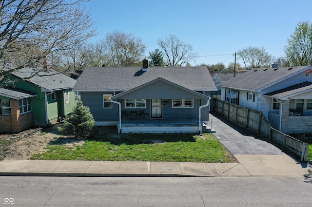1125 N Colorado Ave, Indianapolis, IN 46201 - view of front of property with a chimney, fence, a shingled roof, driveway, and a porch