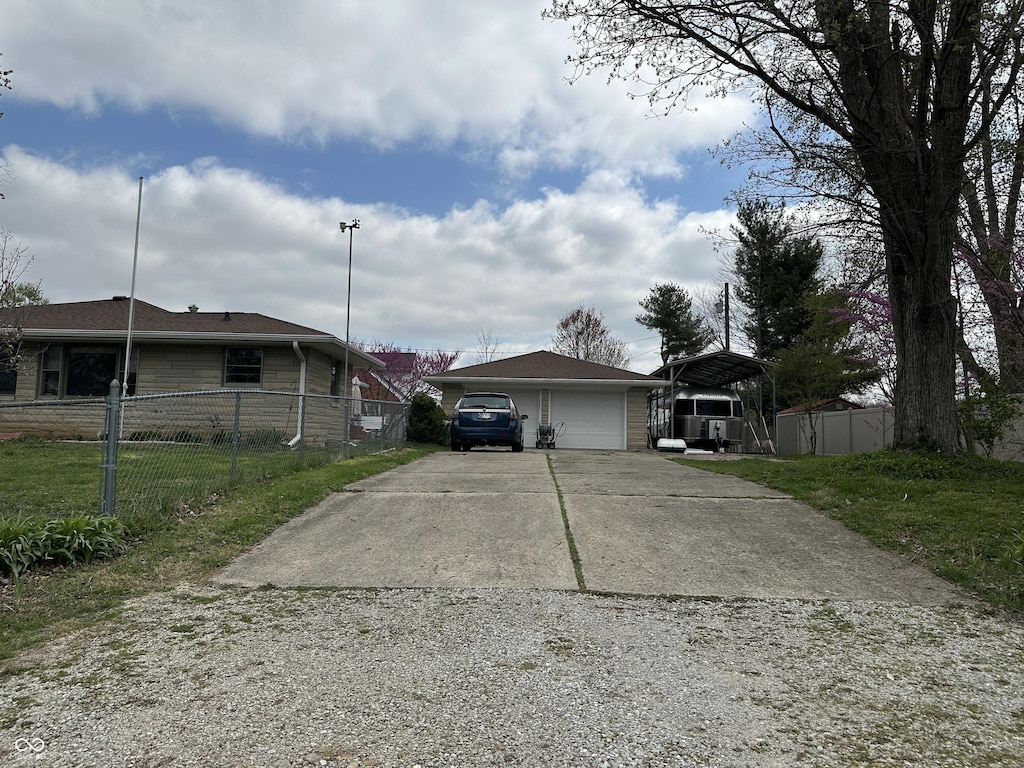 view of front of property with fence, concrete driveway, and a carport