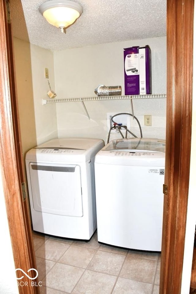 607 Deer Trail Dr, Indianapolis, IN 46217 - laundry room with light tile patterned floors, washer and clothes dryer, laundry area, and a textured ceiling